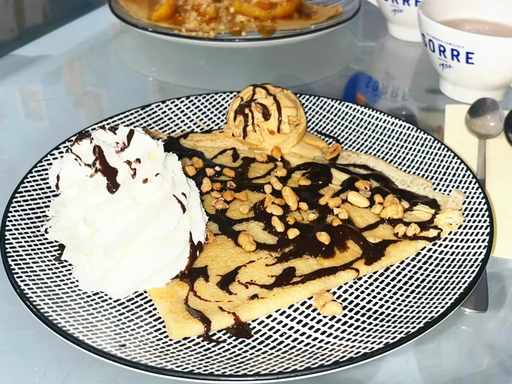 Crêpe signature Mamie Bigoude Wakhol : glace caramel au beurre salé, onctueuse chantilly, nappage chocolat maison et éclats de noix de pécan caramélisées.