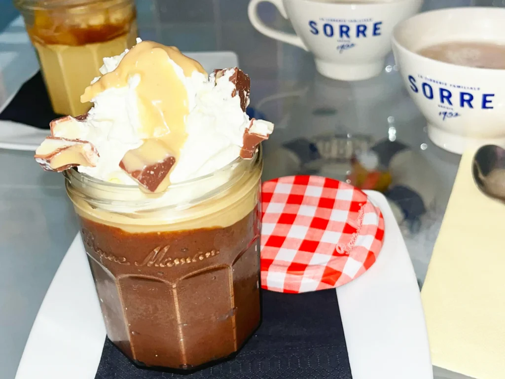 Pot dessert signature Mamie Bigoude Léon : généreuse mousse au chocolat maison, recouverte d'une couche de chantilly, de sauce Kinder et de morceaux de chocolat Kinder.